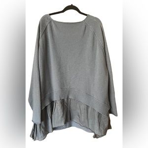 Women’s over sized sweater with ruffle bottom.